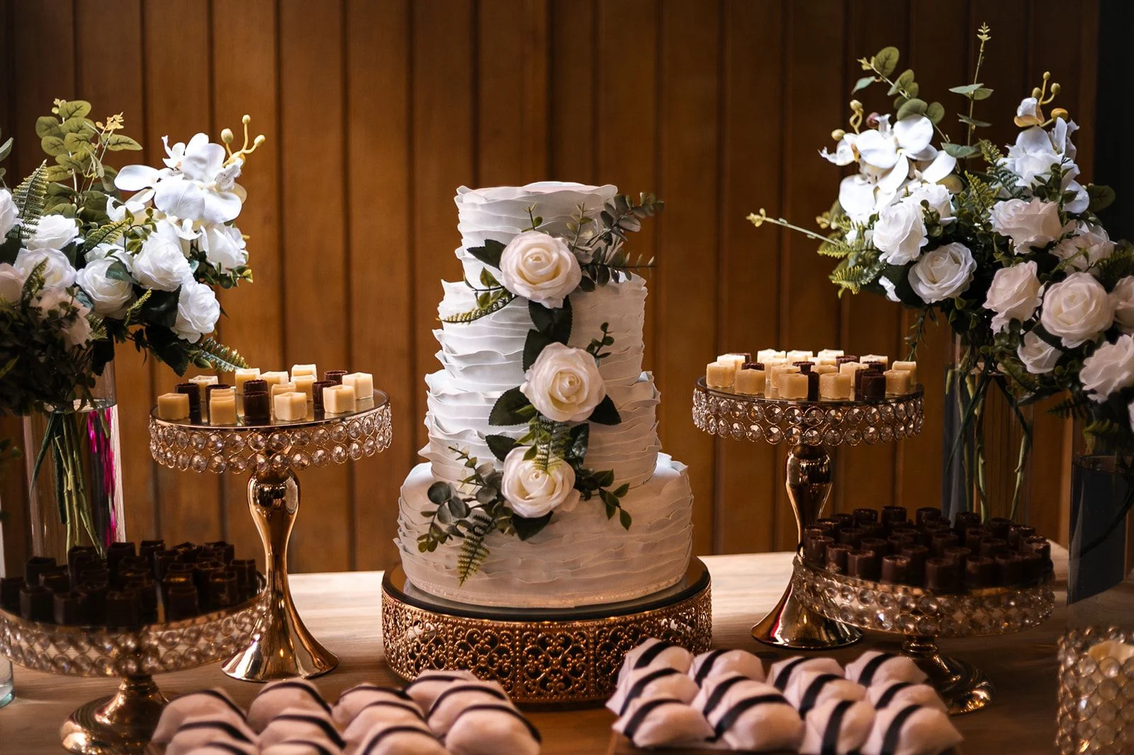 Mesa de doces e bolo decorado com flores brancas